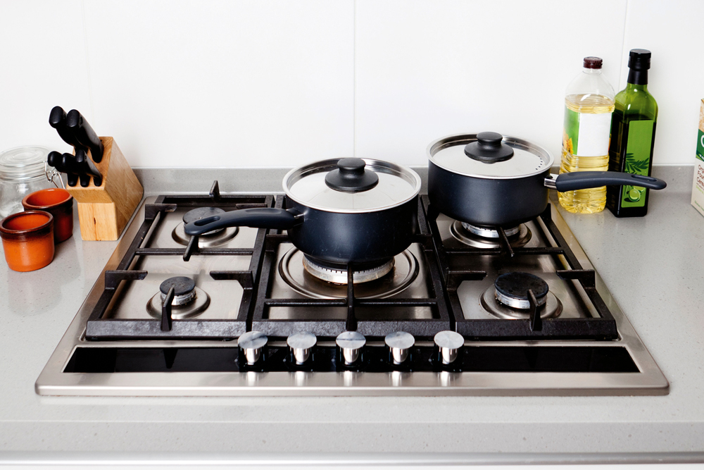 clean stove with pots and pans on top, maintain stoves and rangehoods,