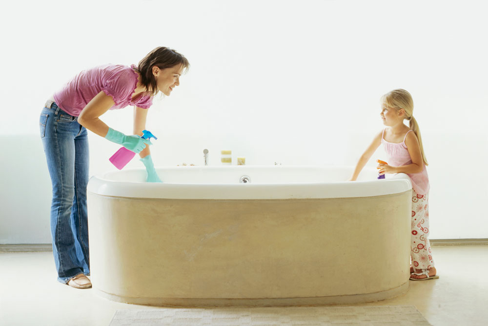 Mother and daughter cleaning a bathtub