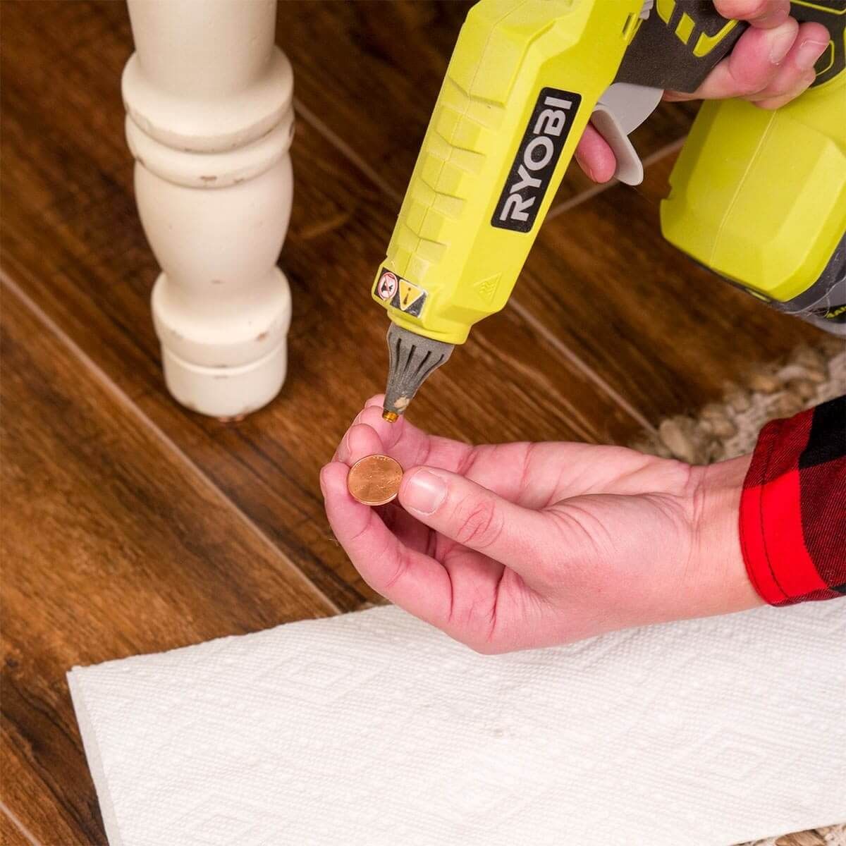Hot glue gun uses: fix wobbly furniture with a coin