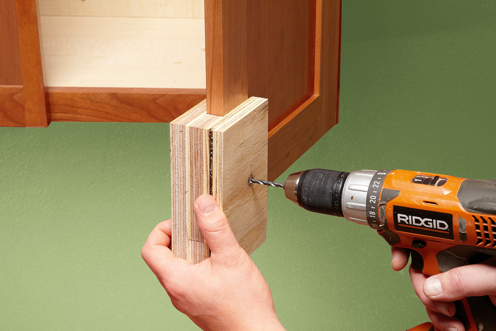 man assemblling a two-sided jig to slot onto the edge of a cabinet door, tips for replacing cabinet handles and drawer knobs, handyman magazine, 