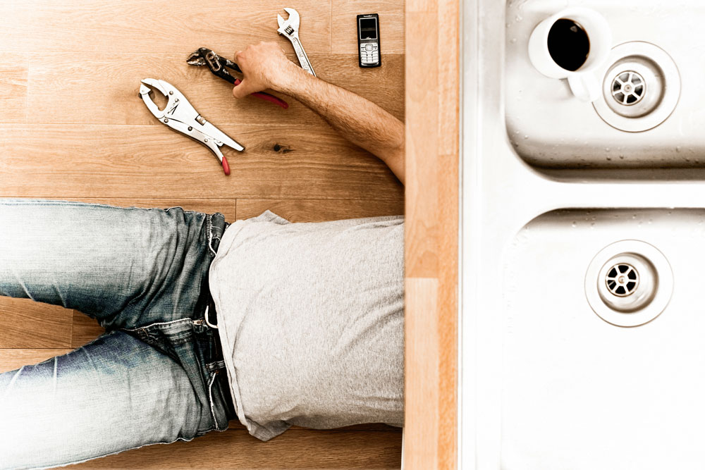 Man fixing under sink, Must-read spring cleaning articles, Handyman magazine 